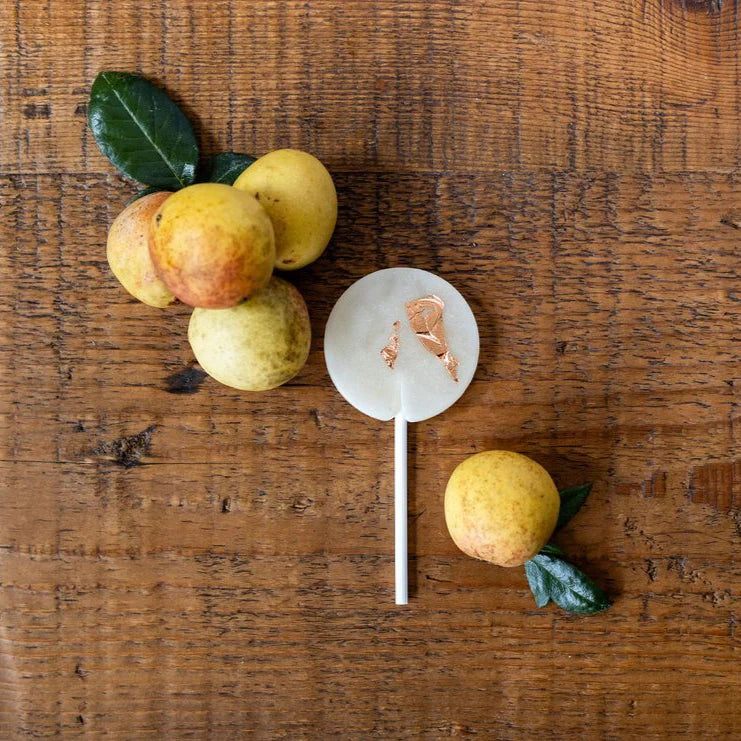Decorative apples on a wooden surface with a small round object in the center.