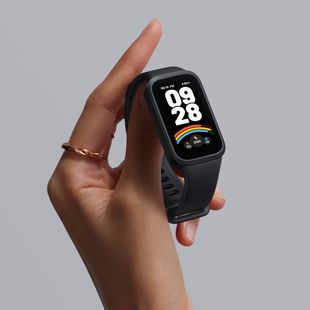 Hand holding a black smartwatch with a gray background