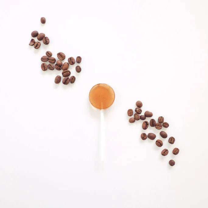 Caramel lollipop with coffee beans on a white background
