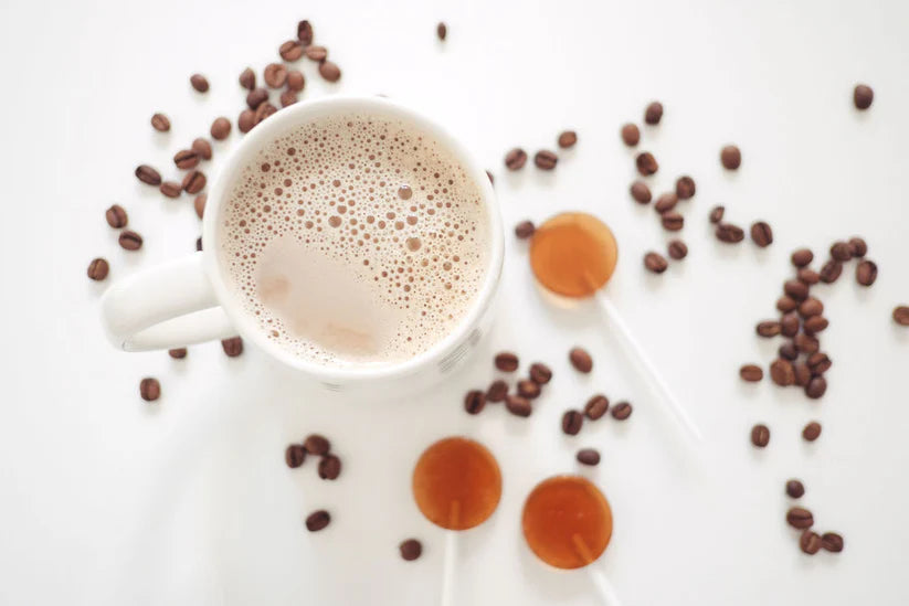 Cup of coffee with coffee beans and syrup on a white background