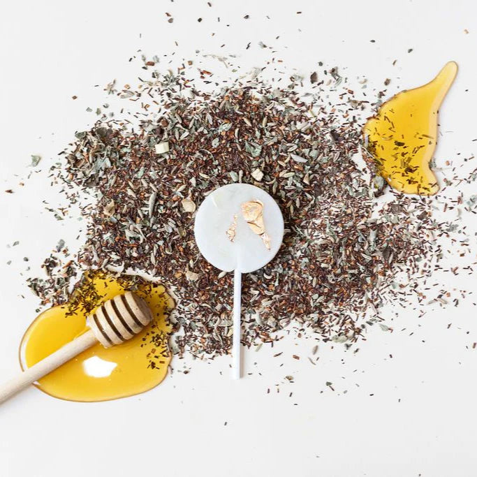 Decorative candle with honeycomb and honey on a white background
